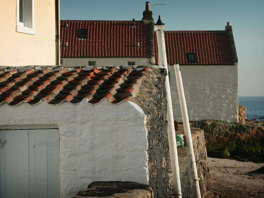 Traditional lime rendered houses with orange pantile roofs, by the sea