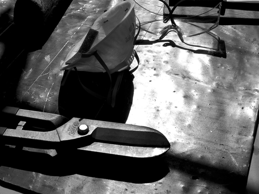 Tools and a clip board sitting on top of a sheet of lead