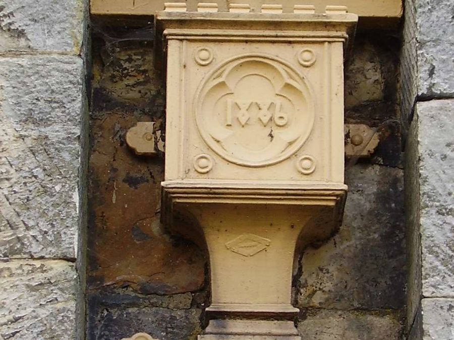 A cream-coloured decorated rainwater hopper