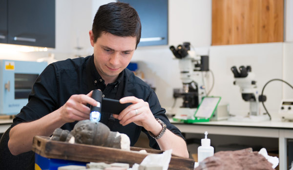 A conservation scientist inspects stone using technology