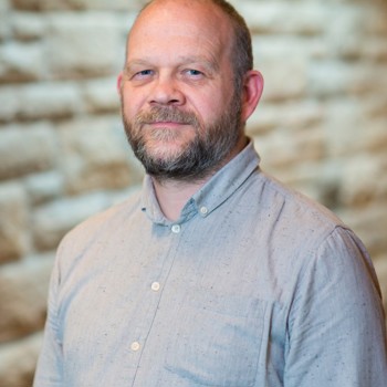 A headshot of Brian smiling