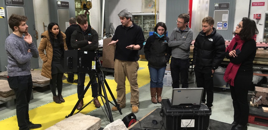 A group learning about stone inside a workshop, looking at different stone types and equipment