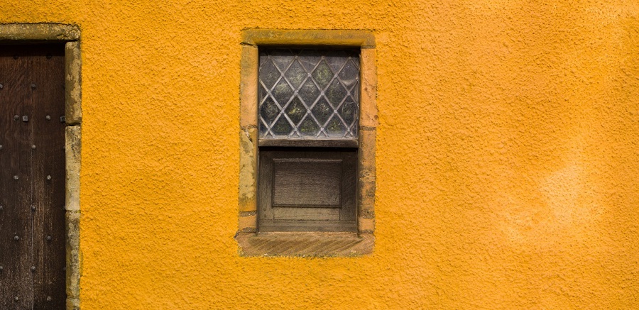 A close up look at yellow lime harling on the side of a building