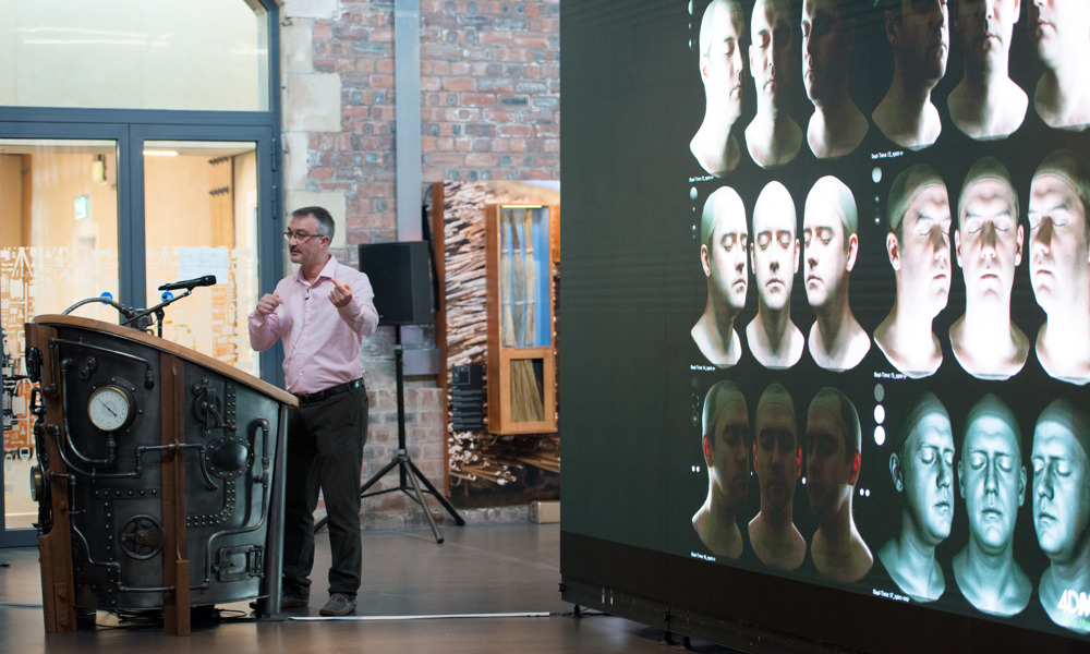 People inside the engine shed looking at a giant screen