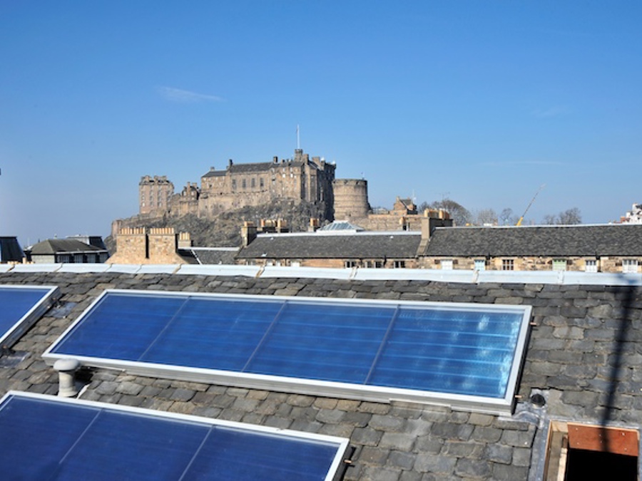 Solar panels on a slate building, looking across to Edinburgh Castle