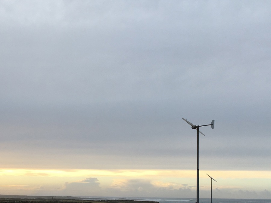 A field with a few small wind turbines in it