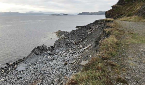 A beach, but instead of sand, the beach is covered in broken slate