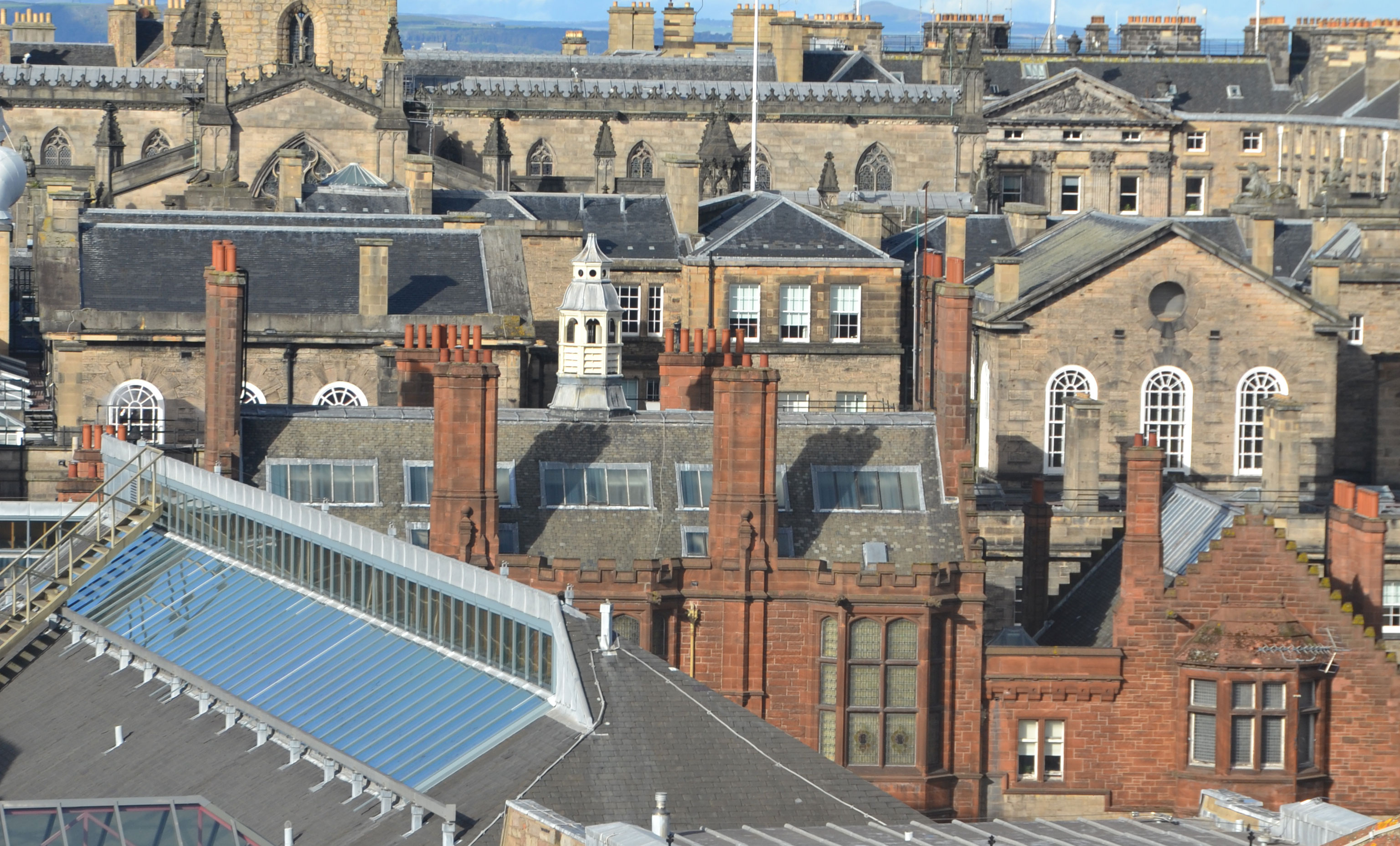 View over Edinburgh rooftops, showing mostly slate roofs and sandstone buildings.