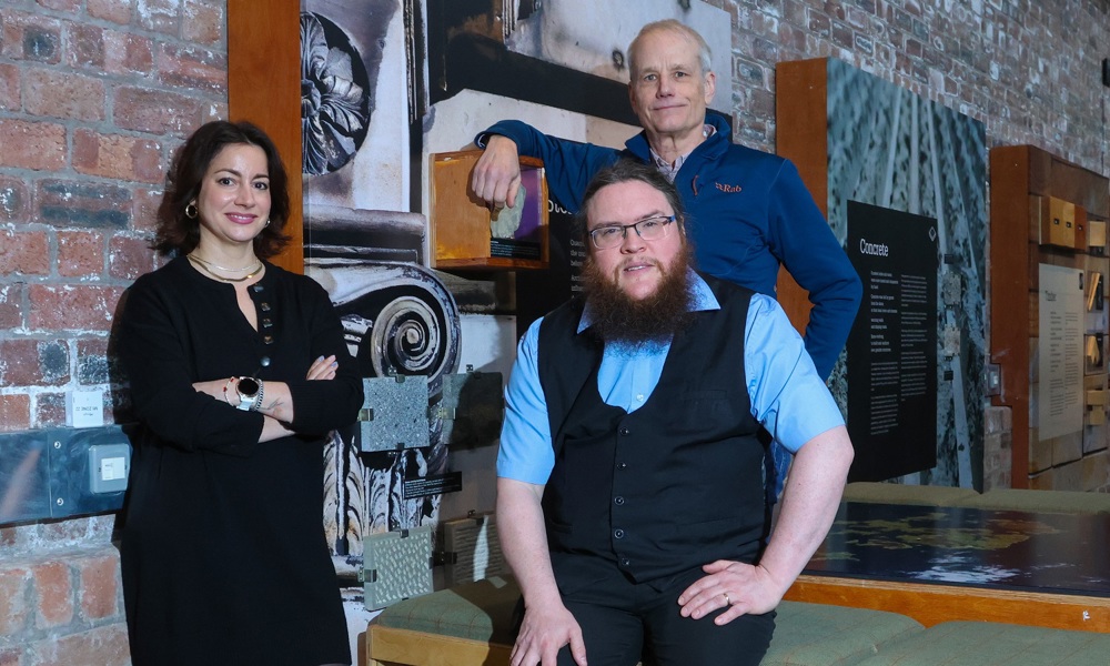 The two tutors and course manager posing next to a display of traditional materials.