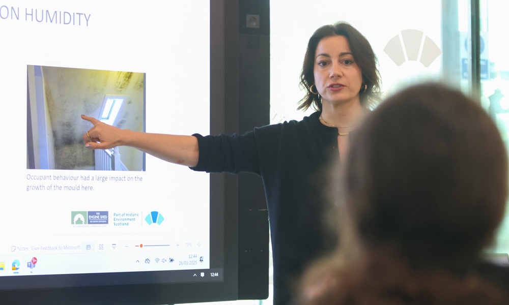 The tutor Lila Angelaka pointing at a slide while presenting.