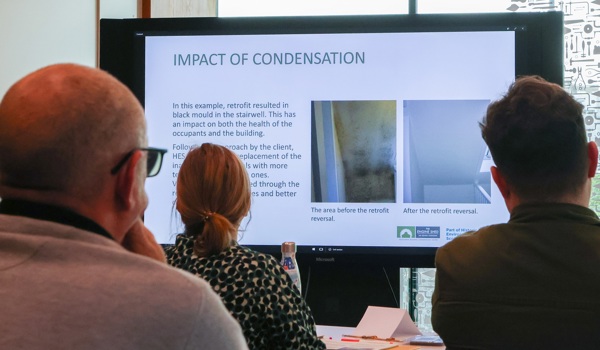 Three learners looking at a presentation slide of 'Impact of condensation'. 