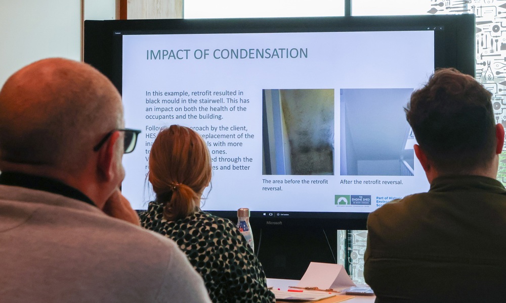 Three learners looking at a presentation slide of 'Impact of condensation'. 
